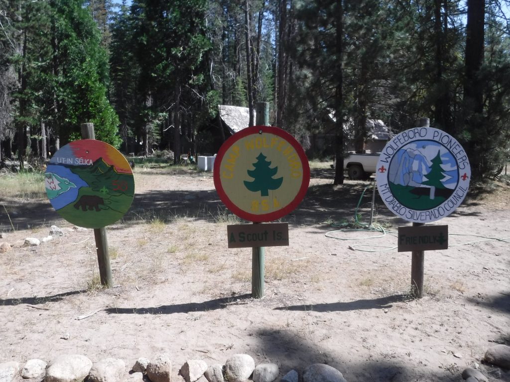 Entry signs representing Camp Wolfeboro, Pioneers and the OA